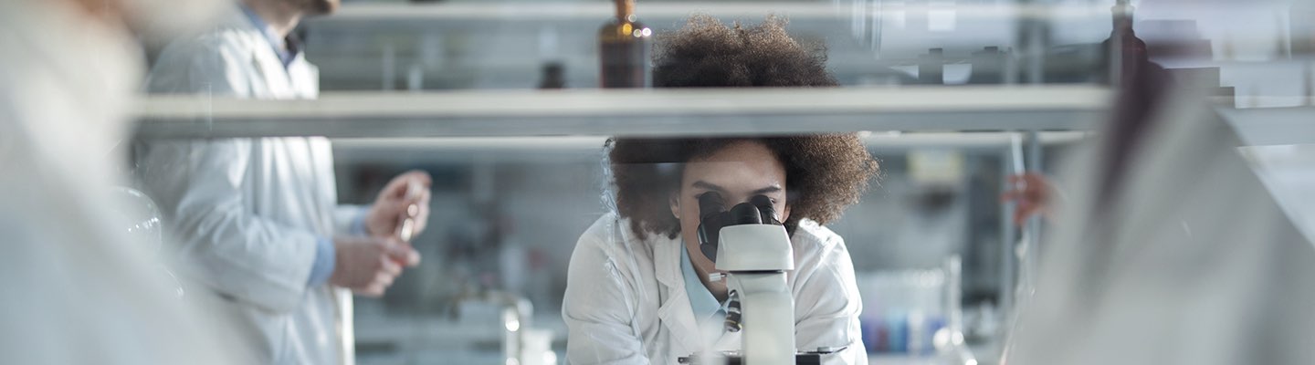 Scientist looking into microscope